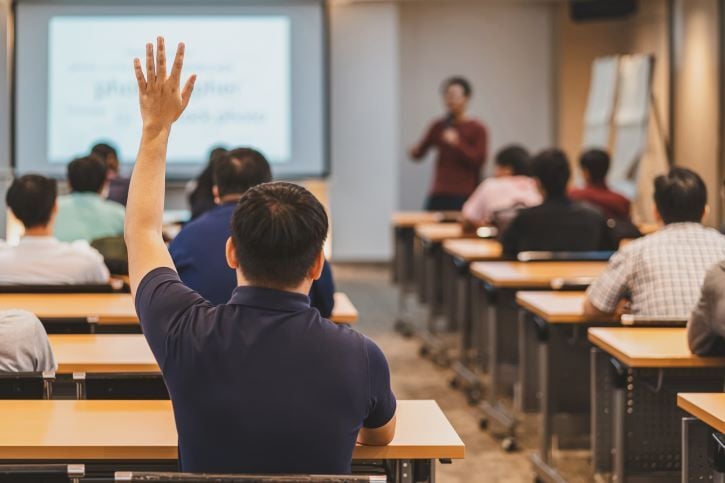 Man holding his hand up in Classroom